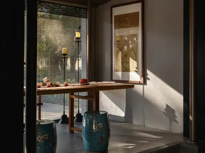 亞洲風格裝飾的餐廳空間，藍色花瓶與盆栽，周圍環繞座椅，營造溫暖親切的氛圍