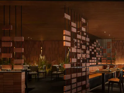 Modern restaurant interior with brick walls, tables, chairs, and potted plants, creating a warm and inviting atmosphere
