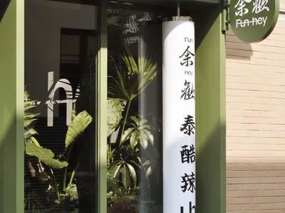 綠色牆面的小型商店，櫥窗展示各式盆栽植物，增添郁鬱蔥蔥的氛圍