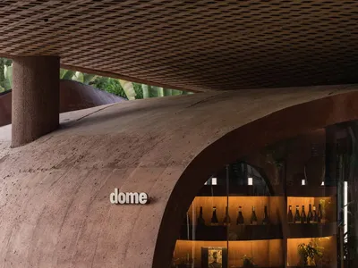 A wine store interior with a glass case displaying wine bottles and a dome structure, conveying a sophisticated ambiance