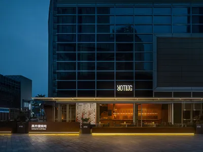 Warm and inviting restaurant with a wooden bar, dining tables, and chairs, illuminated by soft lighting