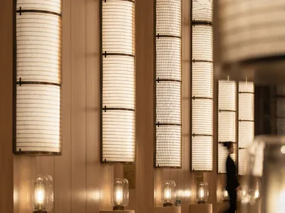 A well-lit hallway with wooden posts supporting row lights, creating a sophisticated ambiance