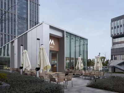 玻璃牆現代餐廳，配有雨傘及戶外用餐區，設有餐桌與椅子