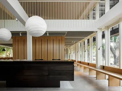 Inviting dining space with multiple tables, round lamps, and comfortable seating