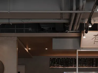 Modern Asian restaurant with a bar area, dining space, and decorative bottles, set in a welcoming atmosphere