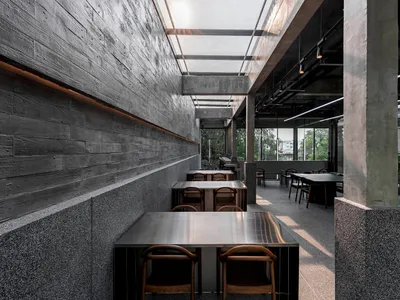 灰石牆現代餐廳內部，眾多餐桌與舒適座椅