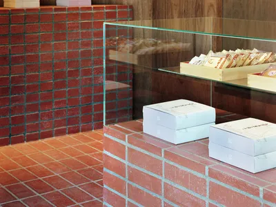 A cozy room with a brick wall and three white boxes on it, suggesting a warm and inviting atmosphere