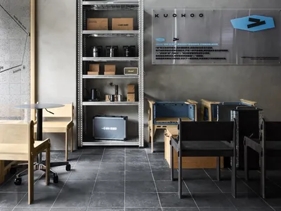 A casual restaurant or cafe with a dining table, chairs, counter, and cups on surfaces, set in a warm and inviting atmosphere