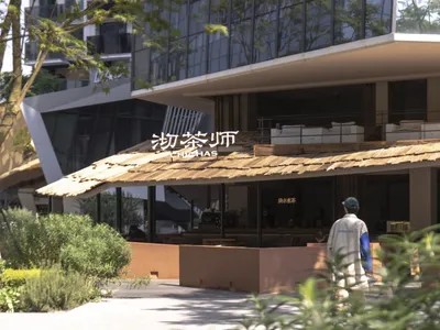 An Asian restaurant with a wooden roof and a large sign, featuring tables, chairs, and multiple people enjoying their time
