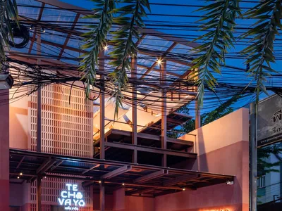 現代露天餐廳，設有用餐區、吧台與盆栽，紅牆營造溫暖氛圍