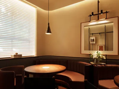 Warm and inviting dining space with brown leather chairs and tables, dimly lit for a cozy ambiance