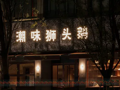 A modern Asian restaurant at night with a lit sign, dining tables, and chairs, illuminated by warm lighting