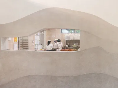 餐廳內部空間，設有桌椅，人們正在交談或工作