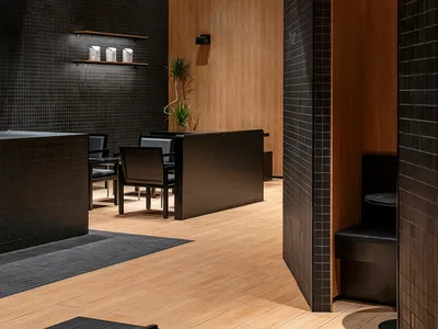 Warm and inviting restaurant interior with wooden walls and floors, featuring chairs and dining tables