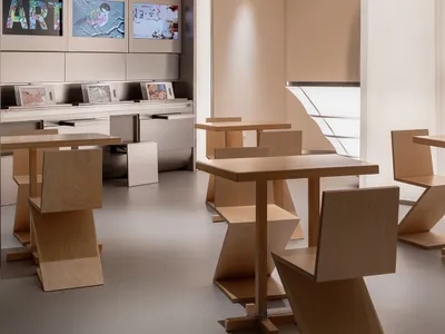Modern restaurant interior with a large dining area, multiple tables, chairs, and TVs on the walls