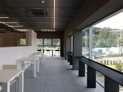 A restaurant dining area with a large white table surrounded by black chairs, creating a comfortable seating arrangement for guests