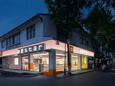 A bustling Asian restaurant storefront at night with a large orange sign reading Star, outdoor dining tables, and a lively atmosphere