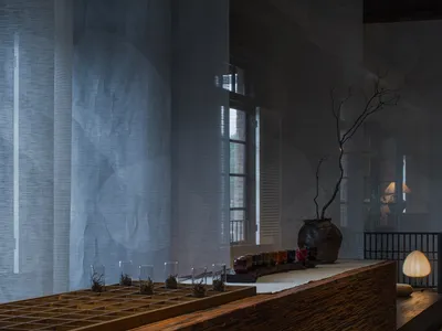 A cozy dining area with a wooden bar counter, wine glasses, and scattered cups, creating a warm atmosphere for socializing and enjoying drinks