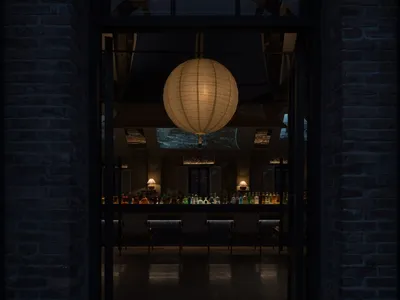 以圓形燈具為焦點的溫馨餐廳，周圍環繞著椅子與餐桌，桌面到處擺放著瓶子