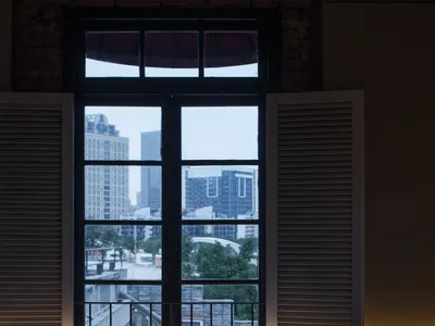 Cozy living space with a large window offering a panoramic city view, two chairs, and a dining table