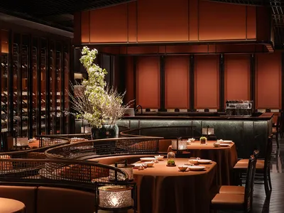 大型用餐區配木皮牆面、多張餐桌椅與酒杯，展現優雅與精緻氛圍
