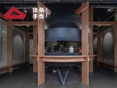 繁忙的商用廚房，配有大型烤箱、兩名人員及廚房設備