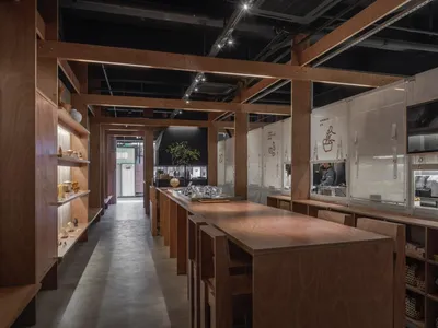 木質地板與牆面的工業風廚房，配有椅子與餐桌，營造乾淨整潔的氛圍
