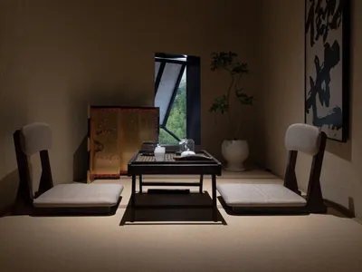 燈光柔和的餐廳，設有餐桌與椅子，牆上飾以亞洲藝術品