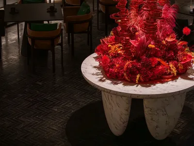 溫暖舒適的餐廳區域，桌上擺放大型紅樹桌飾，周圍環繞座椅，營造出溫馨氛圍