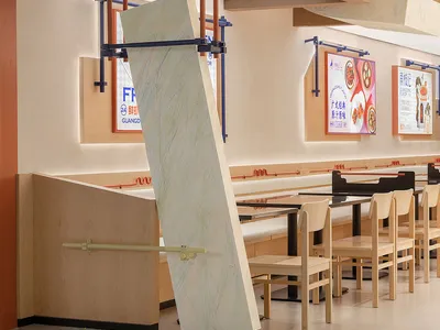 木桌椅餐廳內部，牆面貼滿廣告，乾淨整潔的氛圍