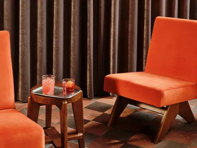 A cozy living area with a fabric chair and wooden table, set up for conversation or relaxation