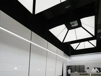Empty restaurant interior with white walls, dining tables, and comfortable seating arrangement, featuring modern simplicity and well-planned lighting