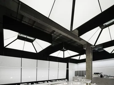 現代餐廳內部，白色牆面、磁磚與地毯地板，搭配多組餐桌椅