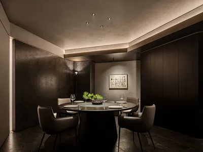 Dining area with a round table, chairs, and artwork on the walls, set in a well-lit modern home
