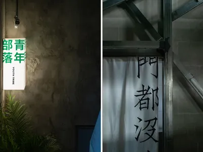 一間光線柔和的臥室，內有床鋪、椅子與洗手台，周圍環繞水泥牆與盆栽，大片窗戶與門廊構成建築場景