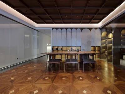 Elegant dining space with a large wooden table, marble top, and several chairs, set in a well-lit room with a modern yet classic design
