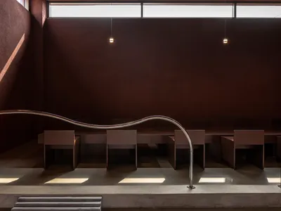 現代餐廳內部，擁有弧形牆面、多張餐桌，以及舒適的客人座椅，自然光與人工照明營造明亮氛圍