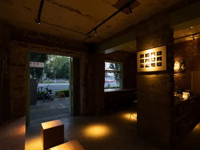 工業風休閒餐廳或酒吧空間，配有椅子、餐桌，背景有自行車
