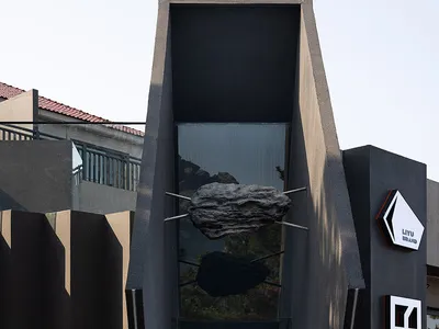 Modern Asian restaurant with a unique rock formation structure, tables, and chairs in a stylish dining space