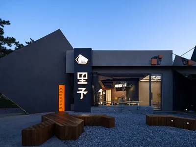 A modern Asian restaurant with a large dining area, tables, chairs, and potted plants, creating an inviting and comfortable atmosphere