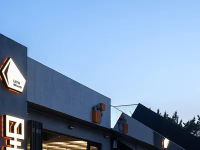 A modern Asian restaurant with black walls, natural light, and dining tables, creating a comfortable atmosphere for guests