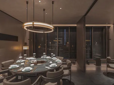 Sophisticated restaurant interior with a large dining table, wooden walls, and wine glasses