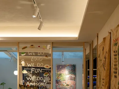 溫暖舒適氛圍中的木桌餐廳區，配有椅子、杯具、盆栽與花瓶
