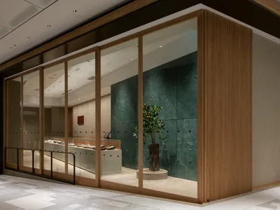 明亮溫馨的商店內部，充滿自然光線、兩株盆栽與大片窗戶
