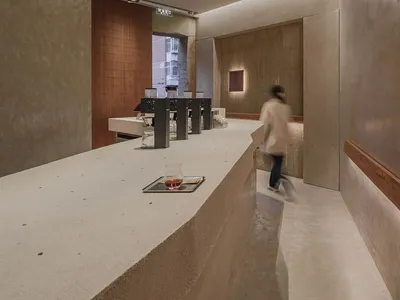 休閒咖啡廳內部，大理石吧台、杯具與人們營造溫馨氛圍