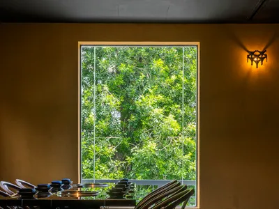 明亮溫馨的餐廳區域，配有大窗戶、椅子，以及擺放各種物品的餐桌