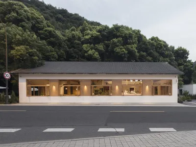 現代飯店或餐廳，白色立面、大片窗戶與盆栽植物，營造溫馨親切的環境