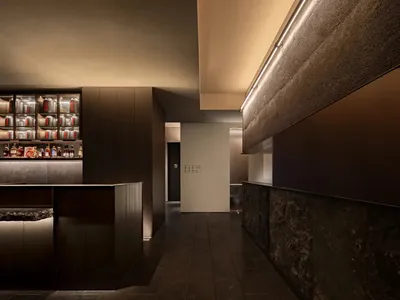 Cozy restaurant interior with wooden floors and walls, featuring bottles and a modern design