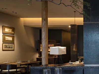 Modern restaurant interior with dining and bar areas, wine glasses, and comfortable seating