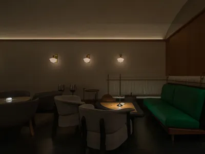 Cozy living room with a green couch, two chairs, a dining table, and a bar area, featuring wine glasses and a comfortable seating arrangement